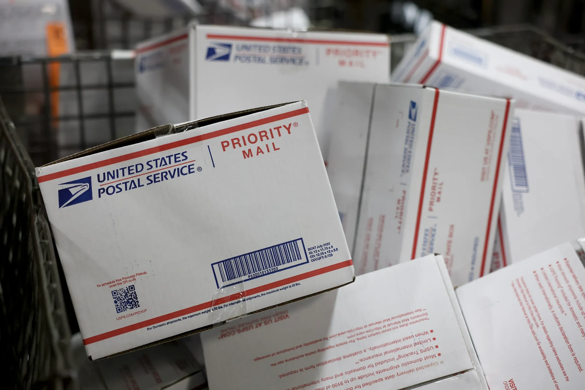 USPS Priority Mail boxes stacked in a bin at a post office