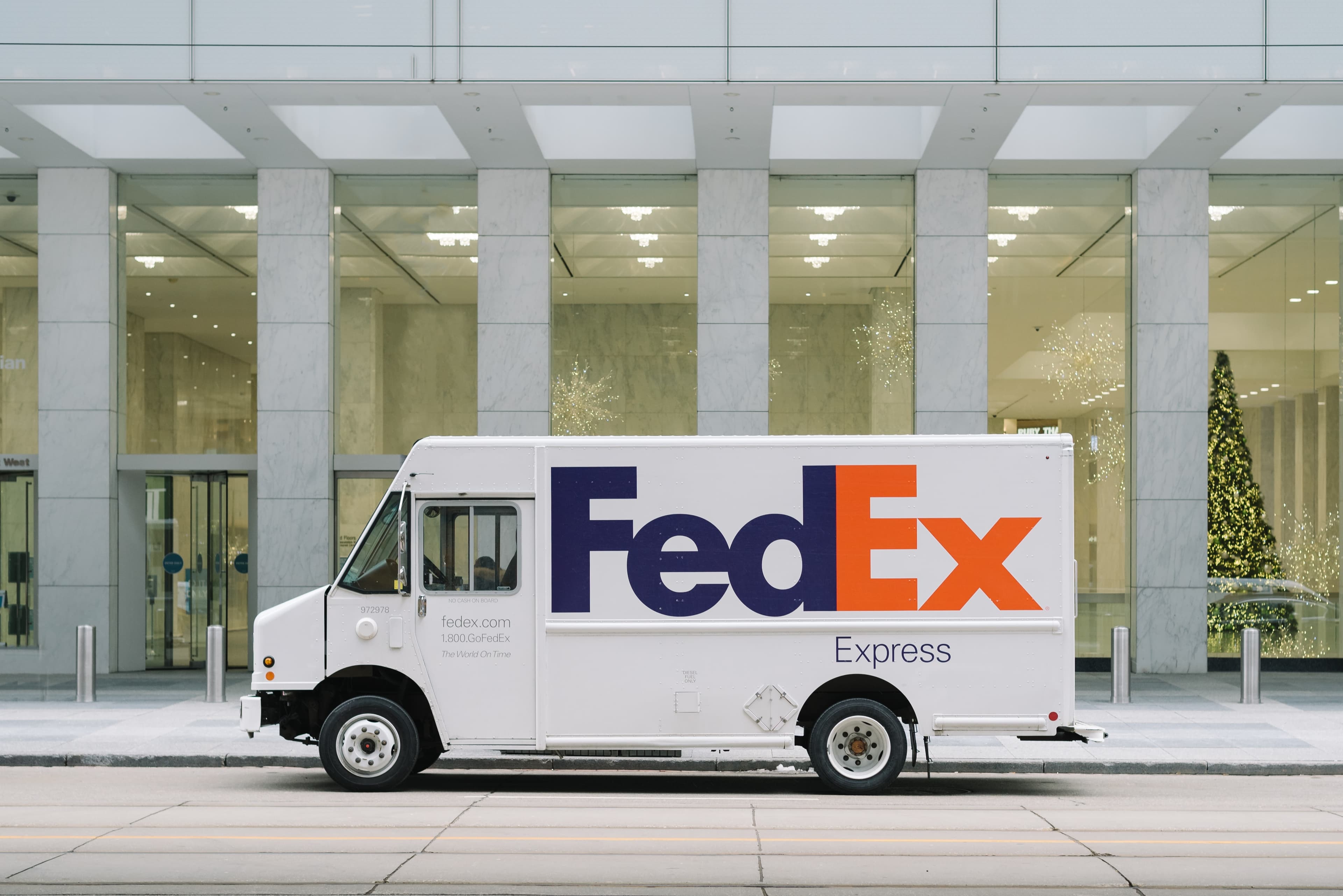 A FedEx delivery courier carrying packages
