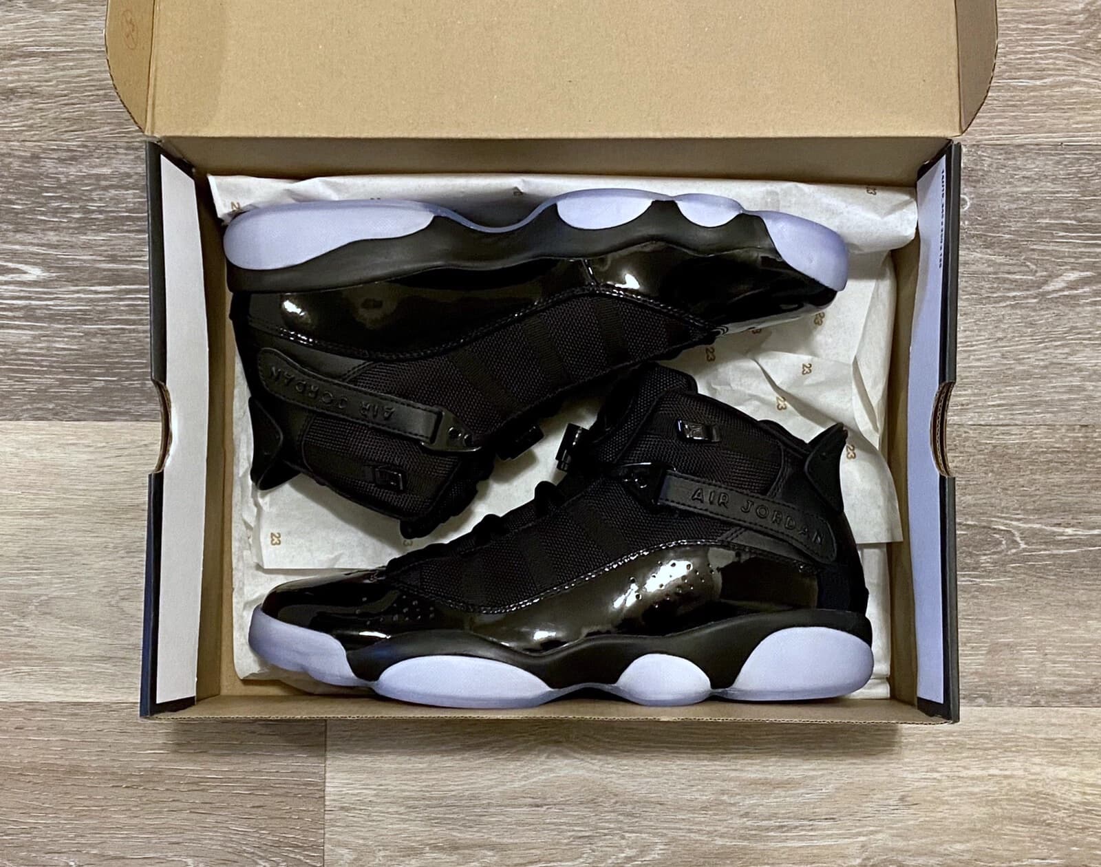 A pair of sneakers being packed into a cardboard shipping box