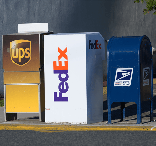 USPS, UPS, and FedEx delivery vehicles side by side